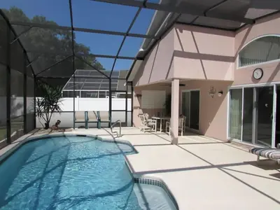 a house with a swimming pool and a patio at Creekside Kissimmee in Kissimmee