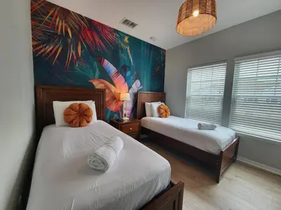 a bedroom with two beds and a painting on the wall at Tropical Getaway with Xbox & PS5 Gaming Paradise in Kissimmee