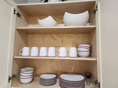 a cupboard filled with white dishes and plates at Tropical Getaway with Xbox & PS5 Gaming Paradise in Kissimmee