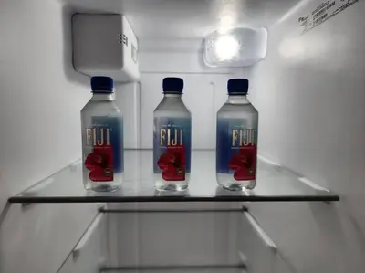 three bottles of water on a shelf in a refrigerator at Tropical Getaway with Xbox & PS5 Gaming Paradise in Kissimmee