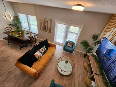 a living room with a couch and a table at Tropical Getaway with Xbox & PS5 Gaming Paradise in Kissimmee