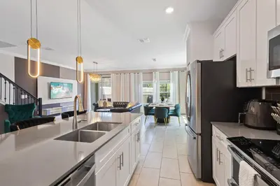 a kitchen with white cabinets and a black refrigerator at 4327 Create Memories in a Magical 5BD Home in Kissimmee