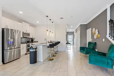a kitchen with white cabinets and green chairs at 4327 Create Memories in a Magical 5BD Home in Kissimmee