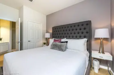a bedroom with a white bed with a black headboard at Cozy Vista Cay Condo right next to Clubhouse in Orlando