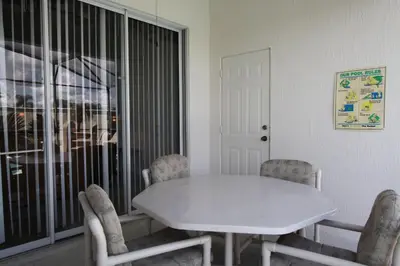 a white table and chairs in a room with a window at Windsor Palm Resort 3 miles to Disney 4 Bedrooms in Kissimmee