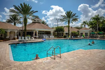 a swimming pool at a resort with people in it at Windsor Palm Resort 3 miles to Disney 4 Bedrooms in Kissimmee
