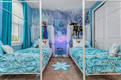 two beds in a room with blue walls at Fairytale Retreat in Orlando
