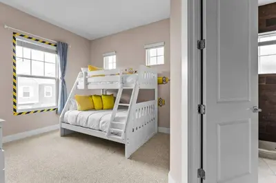a bedroom with a bunk bed with yellow pillows at 5-Suite Disney Escape: Minutes from the Magic in Orlando