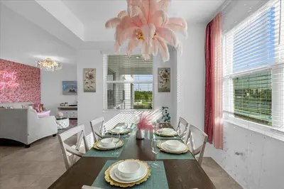 a dining room with a table with chairs and a chandelier at 3191 Paradox Circle 202 in Kissimmee