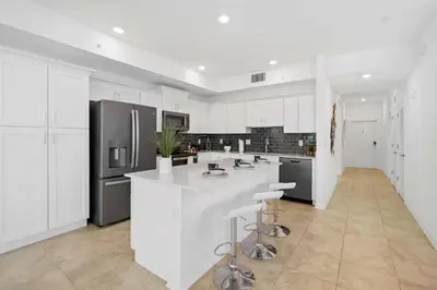 a kitchen with white cabinets and a large white island at 3191 Paradox Circle 202 in Kissimmee