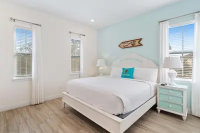 a white bedroom with a bed and two windows at 3050 Pirate Way in Orlando