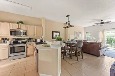 a kitchen and living room with a table and a couch at Harry Potter Themed 3 BR - ER2782 in Kissimmee