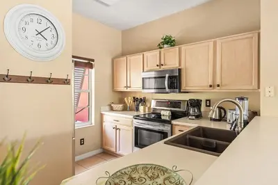 a kitchen with a clock on the wall above a sink at Harry Potter Themed 3 BR - ER2782 in Kissimmee