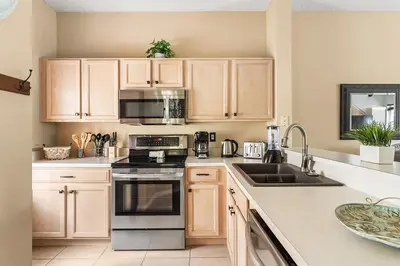 a kitchen with wooden cabinets and a stove top oven at Harry Potter Themed 3 BR - ER2782 in Kissimmee