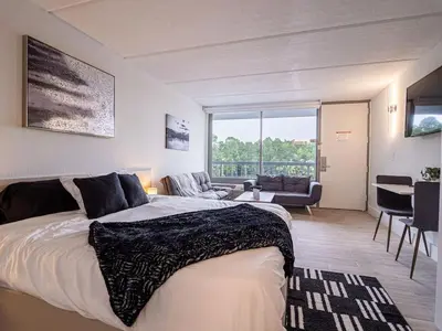 a bedroom with a large bed and a living room at Luxury Orlando 1BR Condo with Pool view & Next to Disney in Kissimmee