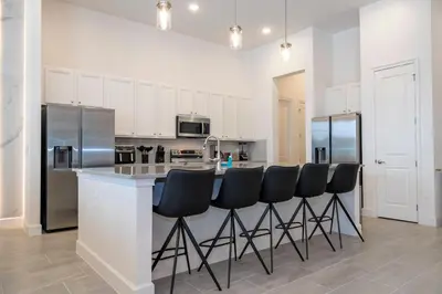 a kitchen with a bar with black bar stools at Sea World neighbor Deluxe Home Up to 33 ppl 5800 in Orlando