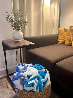 a basket of towels sitting next to a couch at Renovated and cozy apartment near universal in Orlando