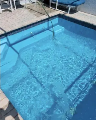 a pool of blue water with two chairs in it at Beautiful 3 bed townhome in Windsor Hills Resort townhouse in Orlando
