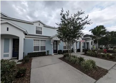 a white house with a tree in front of it at Beautiful 3 bed townhome in Windsor Hills Resort townhouse in Orlando