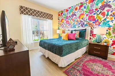 a bedroom with a bed and a colorful wall at 8955 California Palm in Kissimmee
