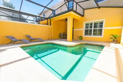 a swimming pool in front of a house at 8955 California Palm in Kissimmee