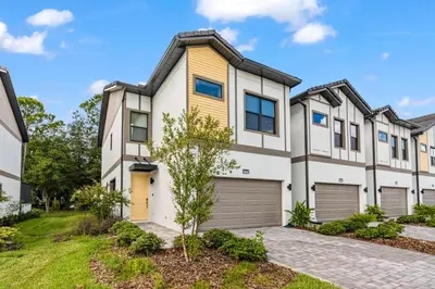 a large white house with a yellow garage at Brand New 5BedroomsPool LED At Paradiso Grande in Orlando