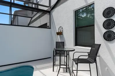 a patio with a table and chairs next to a window at Cozy New 5Bedrooms At Paradiso Grande in Orlando