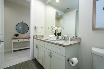 a white bathroom with a sink and a mirror at 2024 Coastal Villa 3 suites near Disney in Orlando