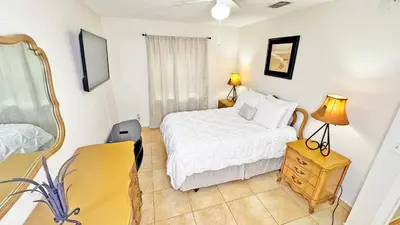 a bedroom with a bed and a desk and a mirror at Vacation Family Home - Close to Disney in Kissimmee