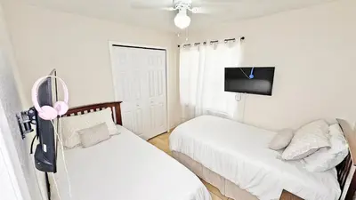 a small bedroom with two beds and a tv at Vacation Family Home - Close to Disney in Kissimmee