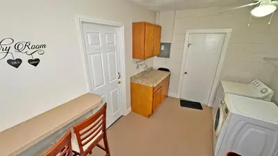 a small kitchen with a sink and a door to a room at Vacation Family Home - Close to Disney in Kissimmee
