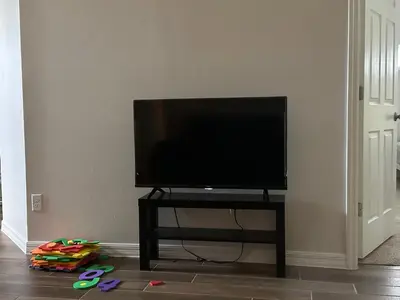 a flat screen tv on a stand in a living room at Sleeps8- WorldCup2026- NearDisney- Universal in Kissimmee