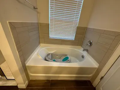 a bath tub in a bathroom with a window at Sleeps8- WorldCup2026- NearDisney- Universal in Kissimmee