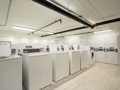 a large laundry room with white washers and dryers at Central Orlando 1BR Retreat & minutes to Disney Parks in Kissimmee