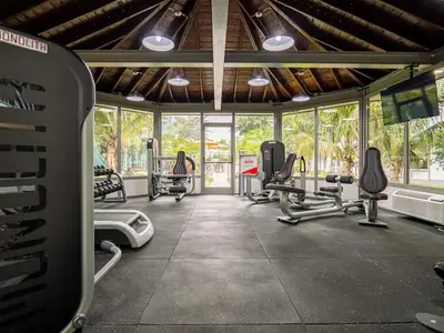 a gym with several treadmills and machines in a room at Orlando 1BR comfort With Lake view minutes to Disney Parks in Kissimmee
