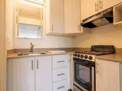 a kitchen with white cabinets and a stove top oven at Orlando 1BR comfort With Lake view minutes to Disney Parks in Kissimmee