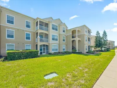 a large apartment building with a green yard at 2304 Silver Palms #205 in Kissimmee