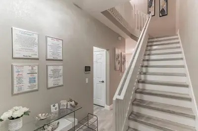 a staircase in a home with a glass table at Modern 4 BR Townhouse near Disney in Kissimmee