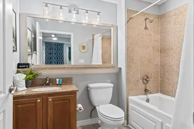 a bathroom with a toilet and a sink and a mirror at Cozy Lakeview Condo near Disney in Orlando