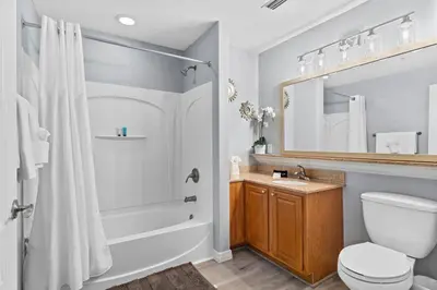 a bathroom with a tub and a toilet and a sink at Cozy Lakeview Condo near Disney in Orlando