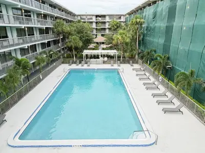 an empty swimming pool with lounge chairs and a building at Spacious 1BR Condo in Orlando and 5 minutes to Disney in Kissimmee