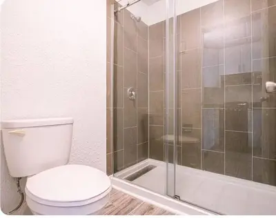 a bathroom with a toilet and a glass shower at Spacious 1BR Condo in Orlando and 5 minutes to Disney in Kissimmee