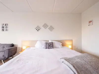 a bedroom with a large white bed and a chair at Spacious 1BR Condo in Orlando and 5 minutes to Disney in Kissimmee