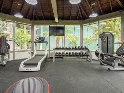 a gym with fitness equipment and a large window at Spacious 1BR Condo in Orlando and 5 minutes to Disney in Kissimmee