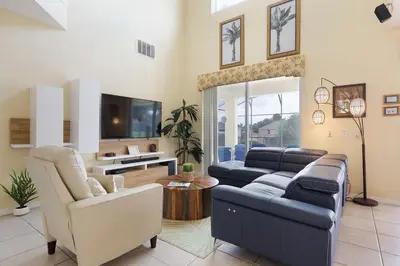 a living room with a couch and a tv at Private Pool, Spa, Game Room & Theme Park Magic in Kissimmee