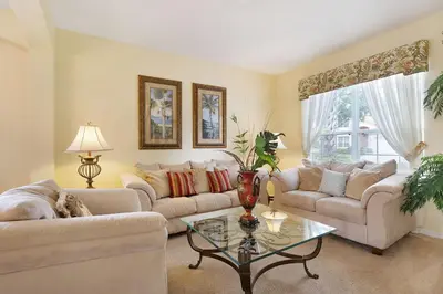 a living room with two couches and a table at Private Pool, Spa, Game Room & Theme Park Magic in Kissimmee