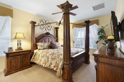 a bedroom with a canopy bed with a wooden frame at Private Pool, Spa, Game Room & Theme Park Magic in Kissimmee