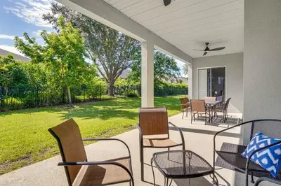 a porch with chairs and a table and a yard at Community Amenities at Spacious Orlando Home! in Orlando