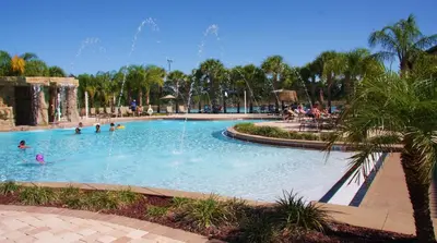 a pool in a park with people playing in it at Orlando Area Vacation Rental with private pool in Kissimmee