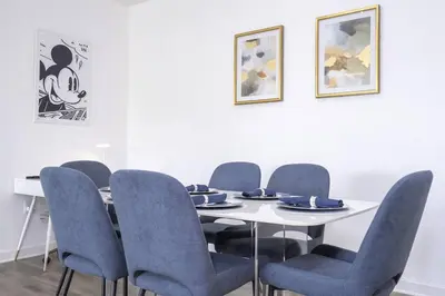 a dining room with a table and blue chairs at A Magical condo close to Disney CSS1 in Kissimmee